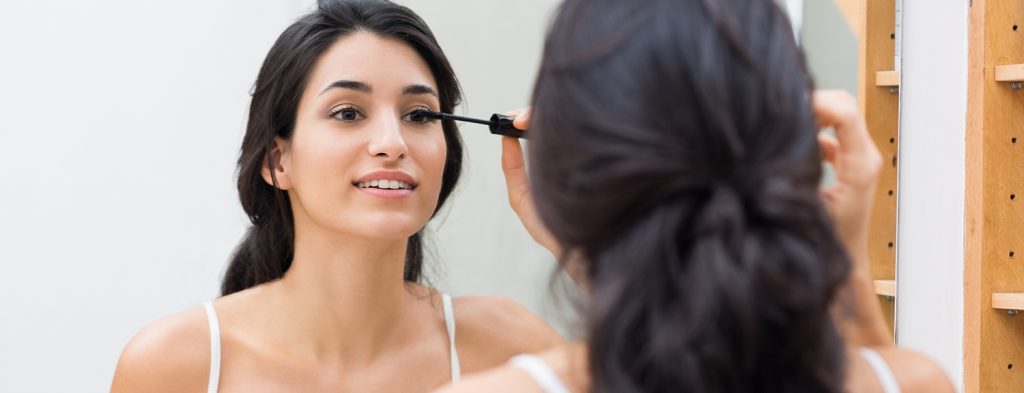 Woman applying mascara on eyelash